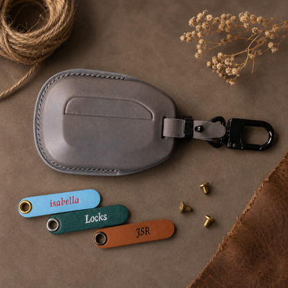 Indian Scout leather key fob cover held in hand with name tags